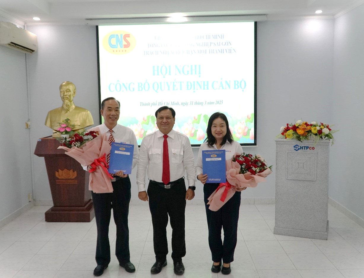 Đồng chí Trần Phi Long, Bí thư Đảng ủy, Chủ tịch HĐTV Tổng Công ty trao quyết định và tặng hoa cho đồng chí Nguyễn Đức Hiền, Trần Thị Lệ Chi